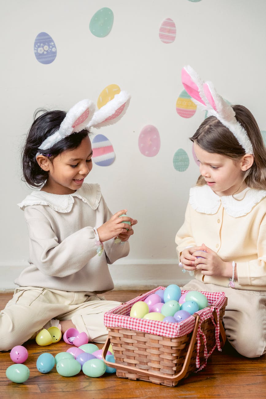 charming diverse girls with decorative easter eggs at home